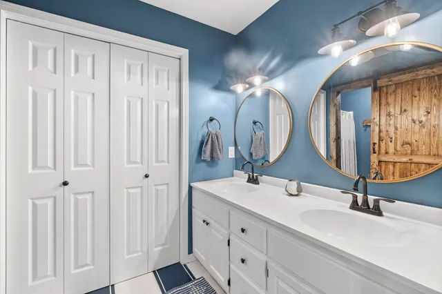a bathroom with double vanity sinks and a mirror