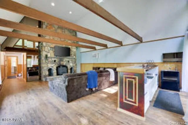 a living room with furniture a fireplace and kitchen view