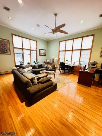 a living room with furniture a ceiling fan and a large window