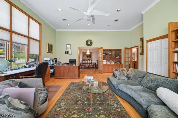 a living room with furniture a large window and wooden floor
