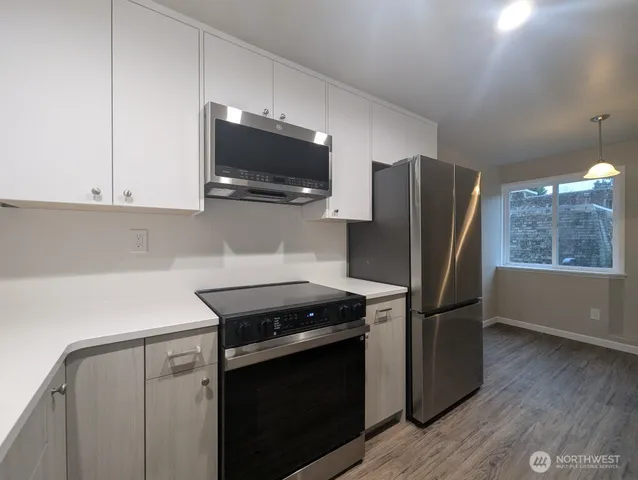 a kitchen with stainless steel appliances a stove microwave and refrigerator