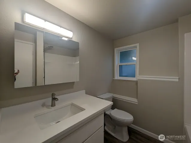 a bathroom with a sink toilet and mirror