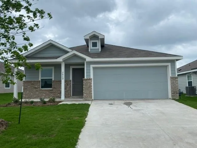 a front view of a house with a garden and yard