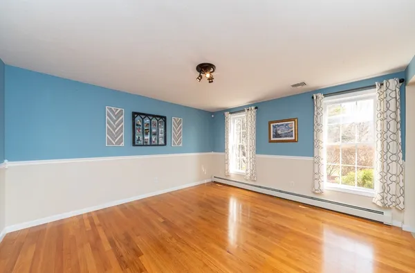 a view of a big room with wooden floor and windows