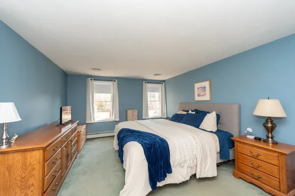 a spacious bedroom with a bed and wooden floor