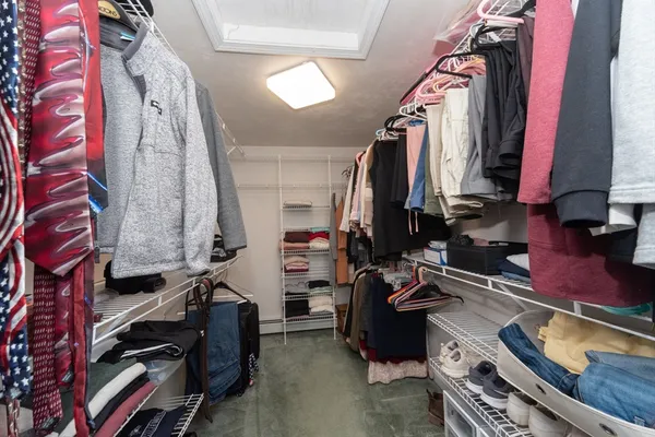 a view of walk in closet with clothes and shoes