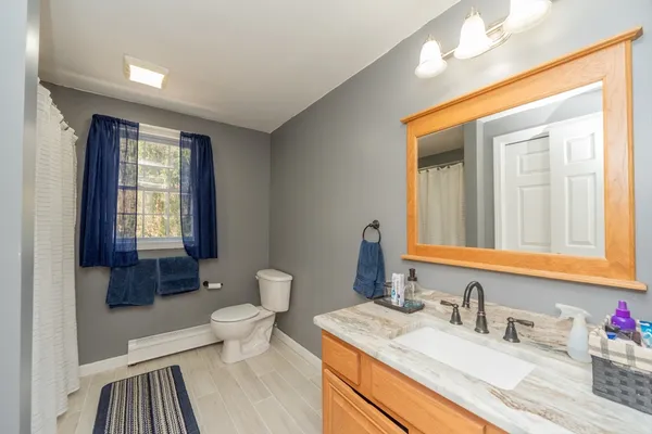 a bathroom with a sink vanity granite and toilet