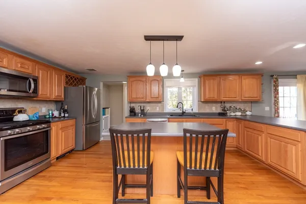 a kitchen with a dining table chairs and refrigerator