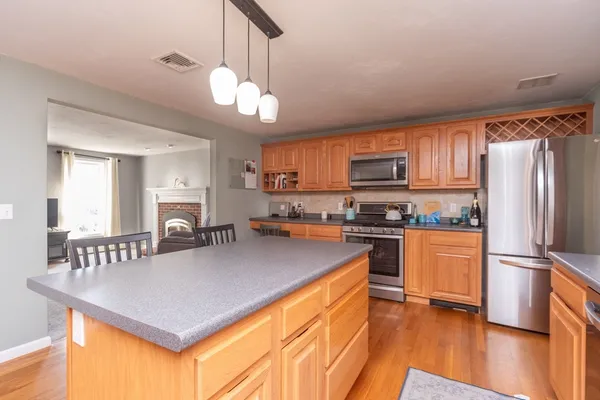 a kitchen with stainless steel appliances granite countertop a refrigerator a stove a sink dishwasher a oven with a dining table and chairs