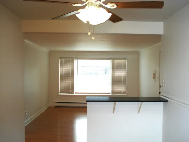 a view of a room with wooden floor and a hallway