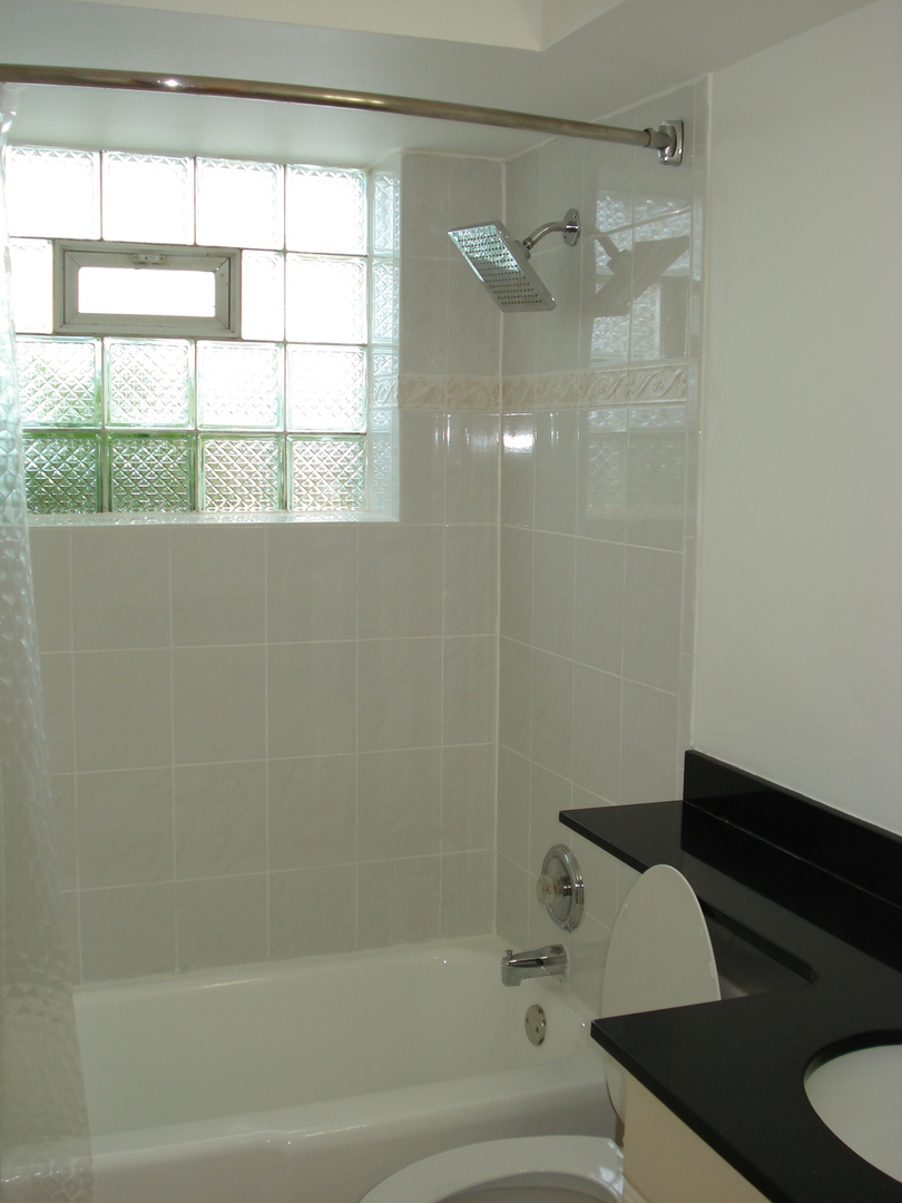 8751 West 79th Street, Unit 1 Justice, IL 60458 - Photo 21 of 32 a bathroom with a bathtub and next to a window