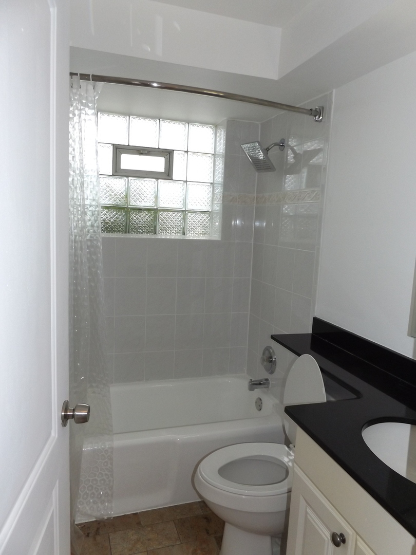 8751 West 79th Street, Unit 1 Justice, IL 60458 - Photo 23 of 32 a bathroom with a granite countertop sink toilet and shower