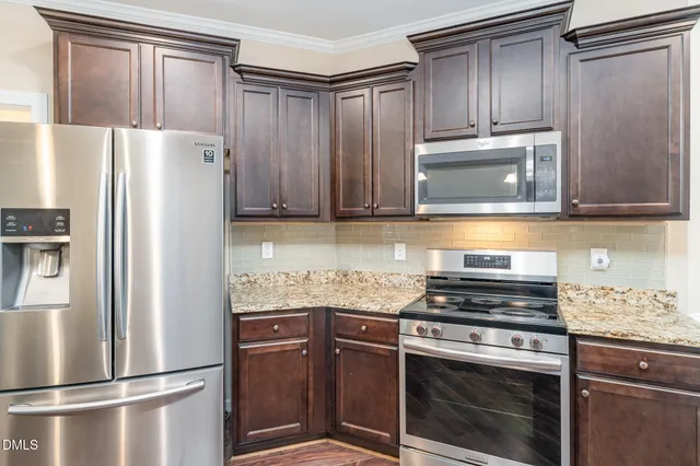 a kitchen with stainless steel appliances granite countertop a refrigerator stove and microwave