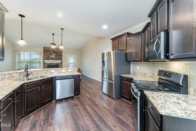 a kitchen with stainless steel appliances granite countertop a sink stove and refrigerator