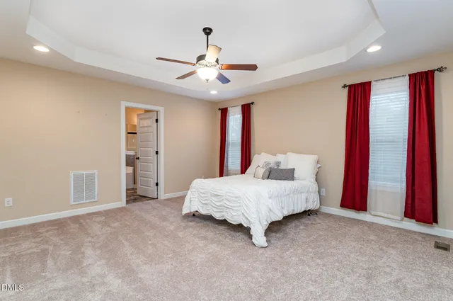 a spacious bedroom with a bed and a chandelier