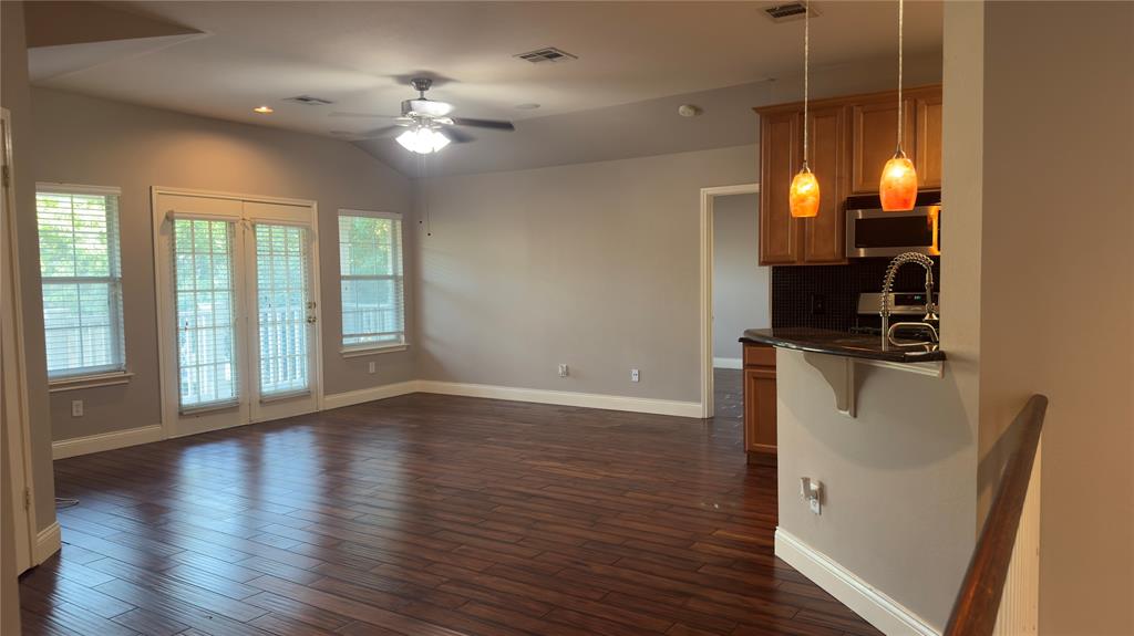 1900 Scofield Ridge Parkway, Unit 5501 Austin, TX 78727 - Photo 2 of 21 A well-lit living area features rich hardwood flooring and a functional kitchen pass-through.