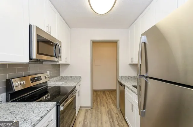 a kitchen with granite countertop a sink stove and refrigerator