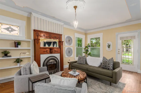 a living room with furniture a fireplace and a chandelier