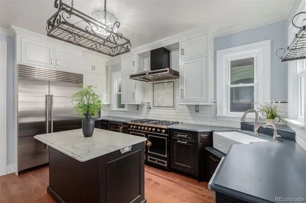a kitchen with stainless steel appliances granite countertop a sink a stove and a refrigerator