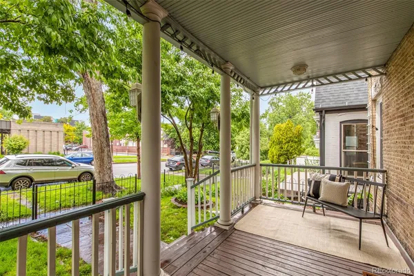 a view of a balcony with chairs and wooden floor