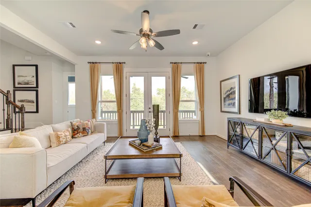 a living room with furniture kitchen view and a wooden floor