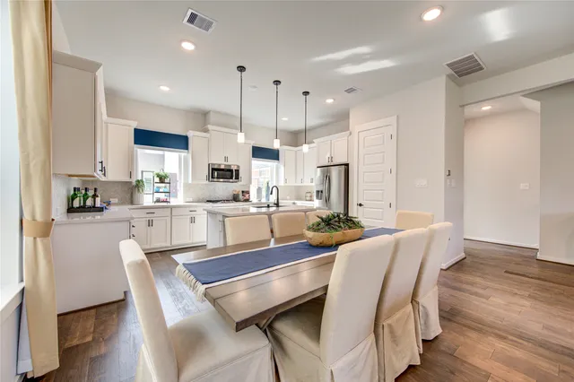 a kitchen with kitchen island granite countertop a stove a sink a center island and wooden floor