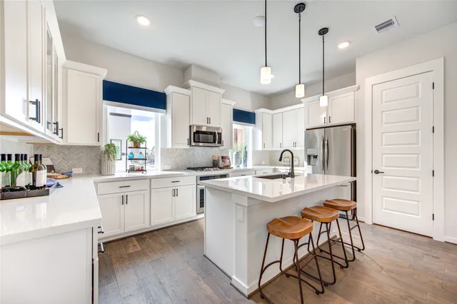 a kitchen with white cabinets and stainless steel appliances