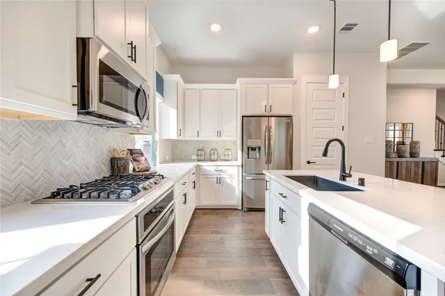a kitchen with stainless steel appliances granite countertop a sink stove and refrigerator