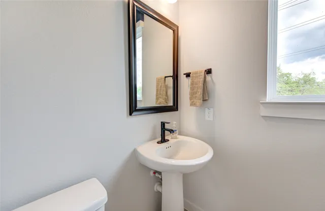 a bathroom with a toilet sink and mirror
