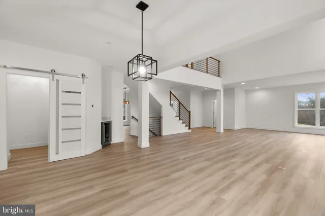 a view of empty room with wooden floor entryway and windows