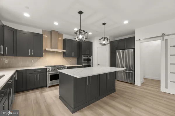 a kitchen with stainless steel appliances granite countertop a sink a stove and a refrigerator