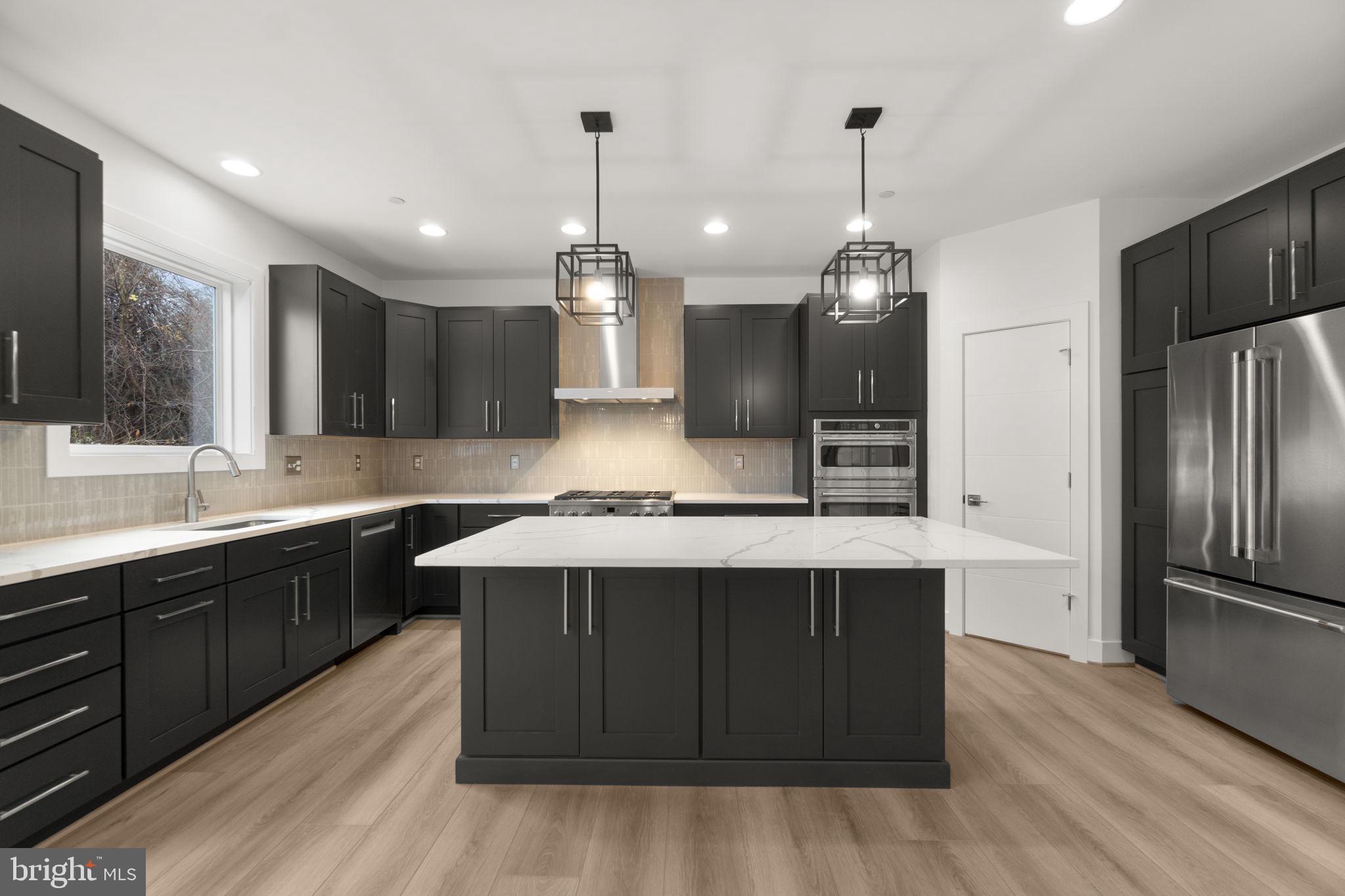 14628 Old Hanover Road, Unit BENTON Reisterstown, MD 21136 - Photo 18 of 69 a large kitchen with a center island wooden floor stainless steel appliances and cabinets