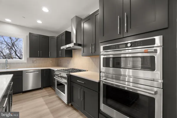 a kitchen with stainless steel appliances granite countertop a kitchen island a stove and a wooden floors