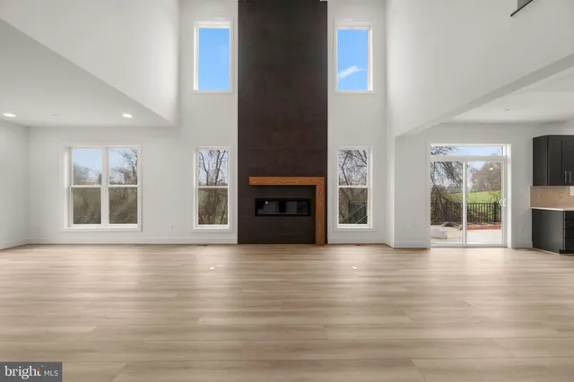 a view of an empty room with wooden floor and a fireplace