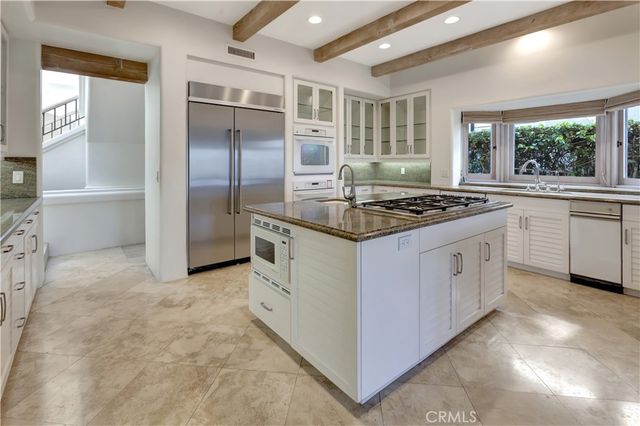 a kitchen with kitchen island granite countertop a stove and a large window