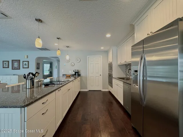 a large kitchen with kitchen island a large counter top space a sink and stainless steel appliances