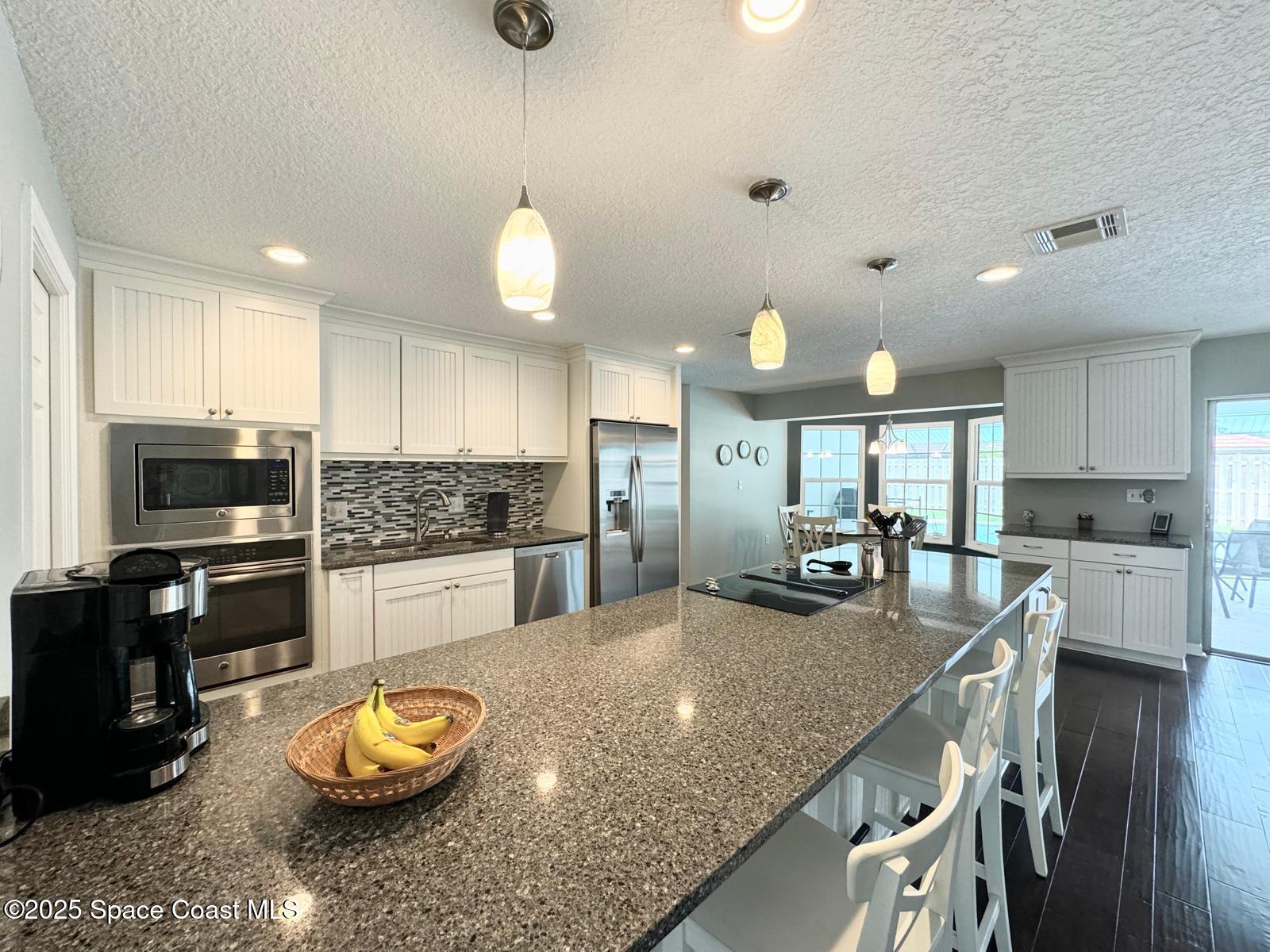 420 Rio Casa Drive North Indialantic, FL 32903 - Photo 18 of 49 a kitchen with stainless steel appliances granite countertop a stove refrigerator and cabinets