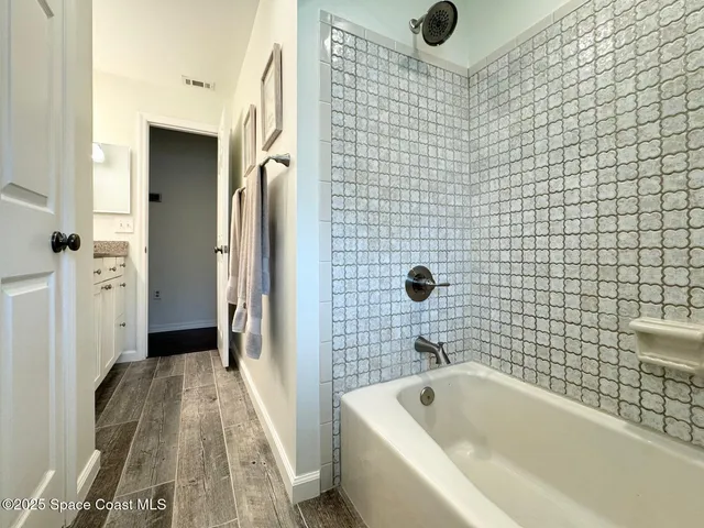 a bathroom with a tub a sink and a shower