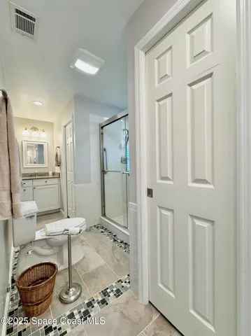 a bathroom with a granite countertop sink a toilet and shower