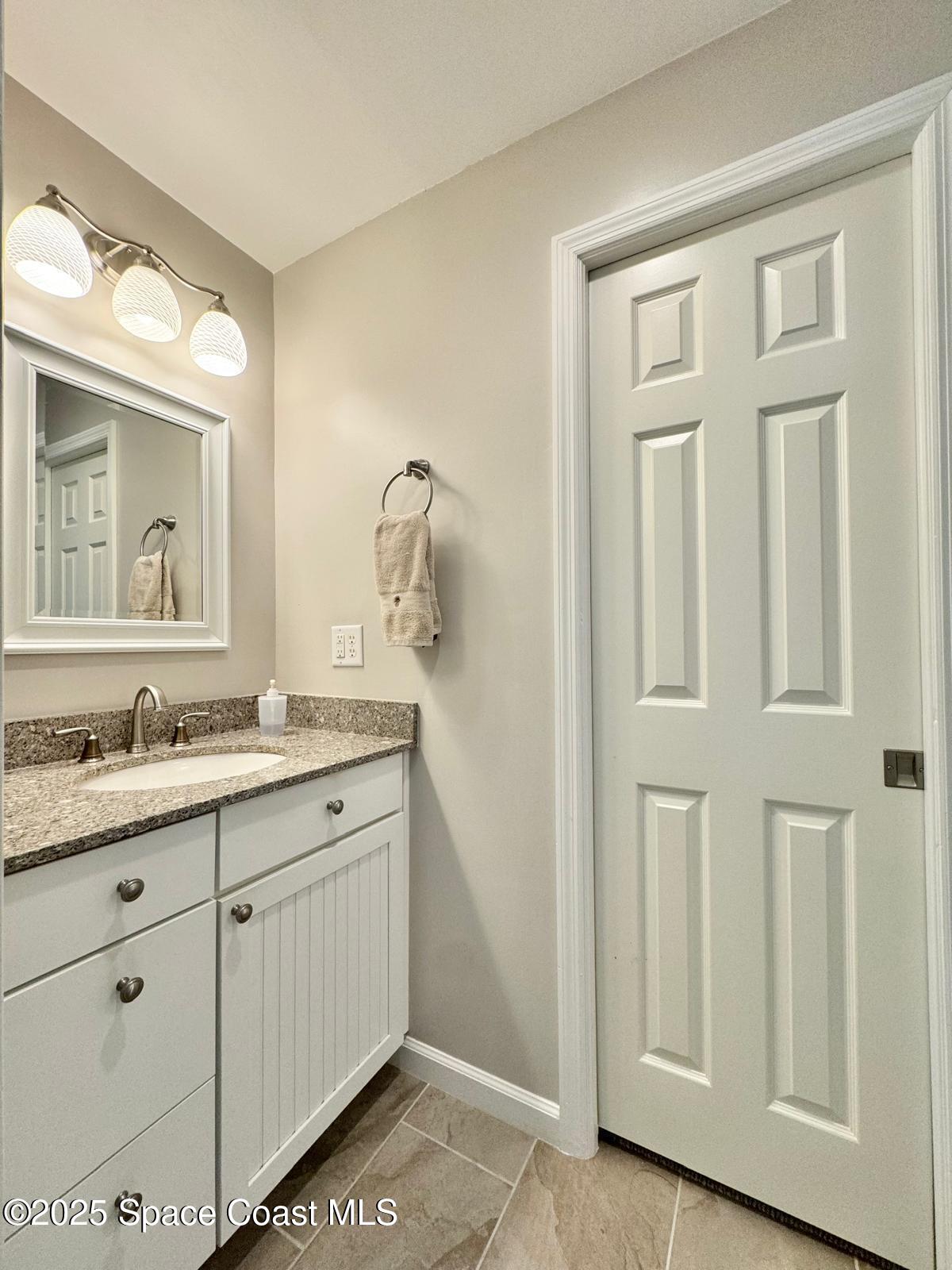 420 Rio Casa Drive North Indialantic, FL 32903 - Photo 41 of 49 a bathroom with a granite countertop sink and a mirror