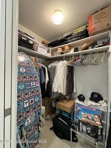 a view of walk in closet with clothes and shoes