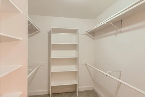 a view of walk in closet with empty racks