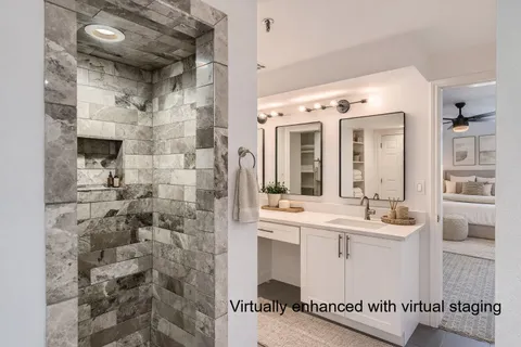 a bathroom with a sink mirror and shower