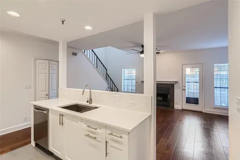 a kitchen with a sink and wooden floor