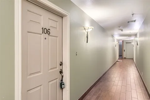 a view of front door with a mirror and a wooden floor