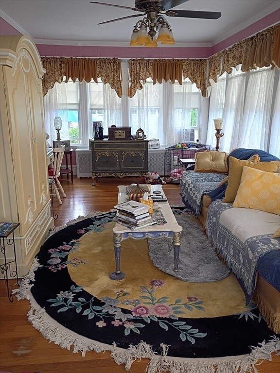 333 Langley Street Fall River, MA 02720 - Photo 26 of 42 a living room with large couches chandelier and a dining table with wooden floor