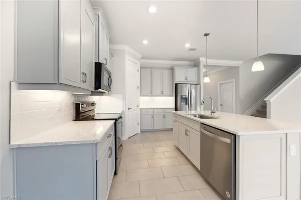 a large kitchen with kitchen island granite countertop a stove a sink a window and a dining table