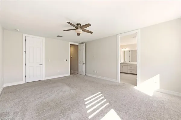 an empty room with fan and windows