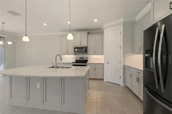 a view of kitchen with kitchen island a sink stainless steel appliances and cabinets