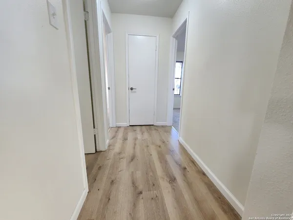 a view of a hallway with wooden floor